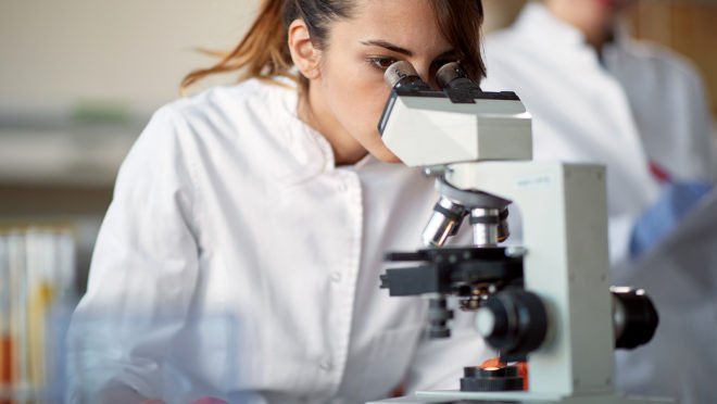Pesquisadora cient\u00edfica analisando resultados em microsc\u00f3pio